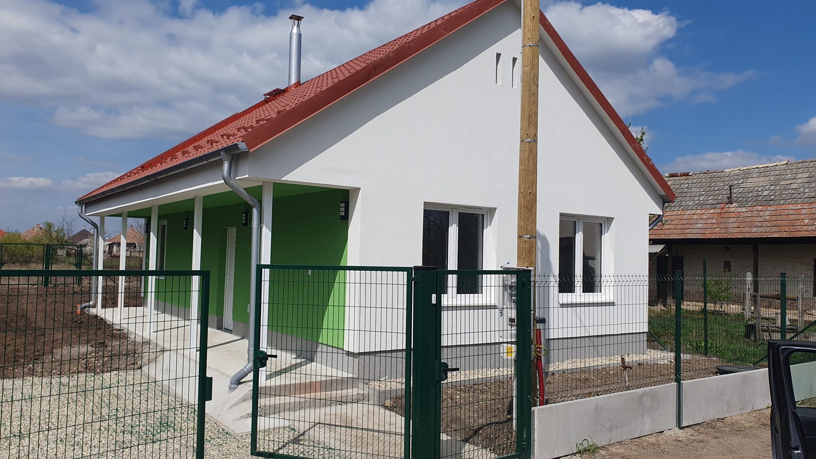 Az elkészült ház Taktaszadán, fedett terasszal és kerítéssel